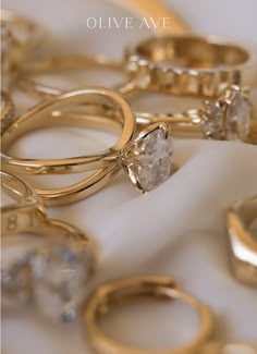 several different types of wedding rings on a white cloth