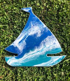 a blue sailboat sitting on top of green grass