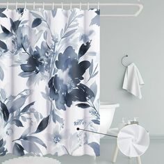 a shower curtain with blue and white flowers on it in a gray room next to a toilet