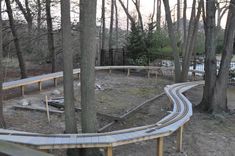 a train track in the middle of a wooded area with trees and other things around it