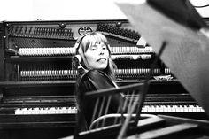 a woman sitting in front of an old piano