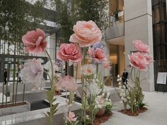 some pink flowers are in front of a building