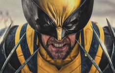 a man in yellow and black wolverine costume with claws on his face, looking at the camera