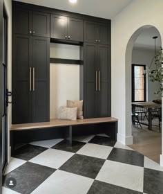 a black and white checkered floor in a room with some cabinets on the wall