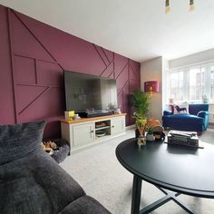 a living room filled with furniture and a flat screen tv on top of a wooden table