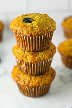 blueberry muffins stacked on top of each other with fresh blueberries in the background