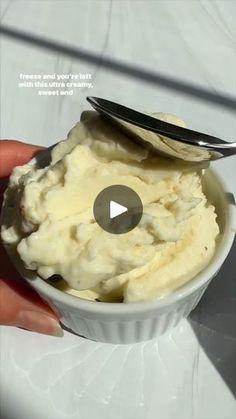 a bowl filled with ice cream sitting on top of a white counter next to a spoon