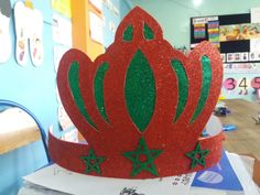 a red crown sitting on top of a pile of books in a room filled with children's toys