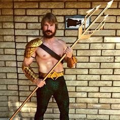 a man dressed up like a warrior with an arrow and snake skin on his chest