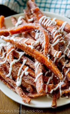 a white plate topped with french fries covered in icing on top of a wooden table