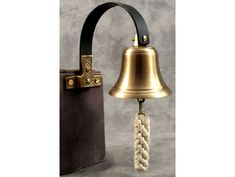 a bell with a rope hanging from it's side next to a black bag