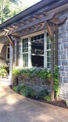 a brick house with an attached pergolan and flower boxes on the front porch