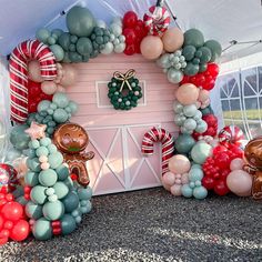 a house made out of balloons and other items in the shape of animals, trees, and wreaths