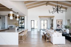 a living room filled with furniture next to a kitchen