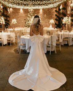 the back of a bride's dress at a wedding in an indoor venue with string lights