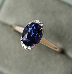 a tan gold ring with a blue stone surrounded by diamonds