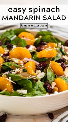 a white bowl filled with spinach and mandarin salad