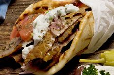 a close up of a taco on a wooden table with other food items around it