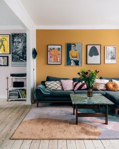 a living room filled with furniture and pictures on the wall above it's coffee table