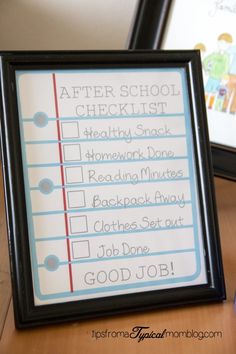 a sign that says after school checklist on the table next to a framed poster