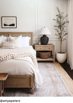 a bedroom with white walls and wooden furniture