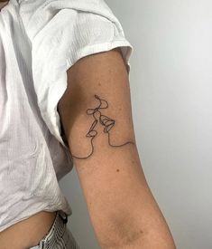 a woman's arm with a tattoo that has a line drawing on the side