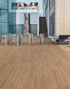 an empty room with wooden floors and glass walls, in the middle of a building