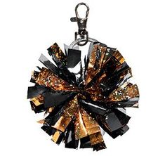 a black and gold keychain with lots of small pieces of material on it