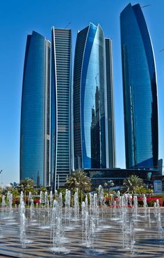 the fountains are in front of some very tall buildings