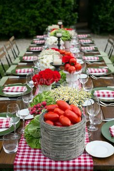 a long table with red and white checkered cloths, green place mats and plates