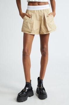 A branded elastic waistband features in tucked-in or cropped-top pairings with these cargo-influenced rave shorts cut from peached cotton twill. 3" inseam; 27" leg opening; 11" front rise; 16" back rise (size 2) Side zip closure Cargo bellows pockets; back flap pockets 100% cotton with 64% nylon, 22% polyester, 14% elastane waistband Dry clean Imported Designer Clothing Utility High-waisted Shorts With Patch Pockets, Khaki Cargo Shorts With Belt Loops For Summer, Summer Khaki Cargo Shorts With Belt Loops, Summer Cargo Pants With Multiple Pockets, Cotton Cargo Skirt With Elastic Waistband For Summer, High-waisted Utility Cargo Shorts, Utility High-waisted Cargo Shorts With Belt Loops, Utility Cargo Shorts With Short Legs, Relaxed Fit Cargo Style Shorts For Summer