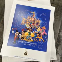 the disneyland poster is on top of some paper and it's still in its packaging