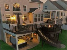 an aerial view of a house at night with lights on the deck and patio area