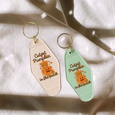 two keychains that say cutest pumpkins and one has a bear on it