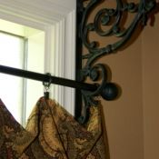 the curtain is hanging in front of the window with an ornate iron design on it