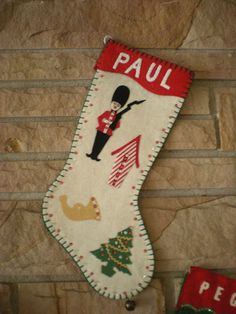 a christmas stocking hanging from the side of a brick wall next to a sign that says paul