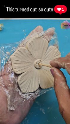 someone is making a flower out of clay