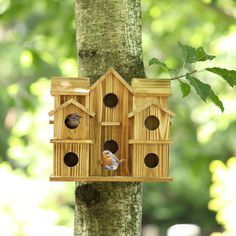 a wooden bird house hanging from a tree