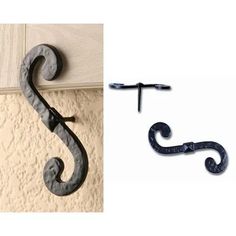 an iron hook on the side of a wall next to a pair of metal hooks