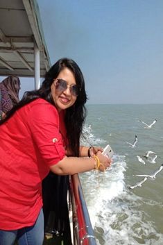 a woman in red shirt on boat with seagulls