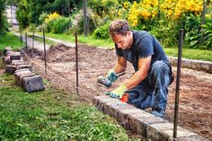 a man is working in the garden with some bricks and weeding tools on his hands