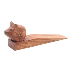 a wooden cat figurine sitting on top of a piece of wood with its eyes closed