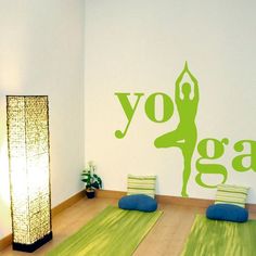 a yoga room with green mats and wall decals