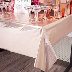 the table is set up with pink flowers and champagne glasses for guests to take home