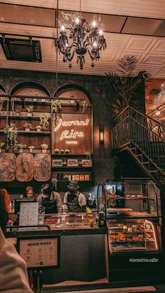 the inside of a restaurant with lots of counter space and chandelier hanging from the ceiling