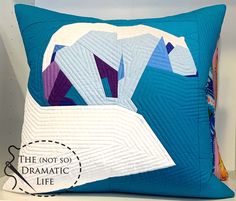 a blue pillow with an origami polar bear on it's side and the words, the not so dramatic life below