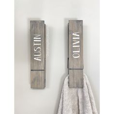 two wooden signs are hanging on the wall next to a white towel and some towels