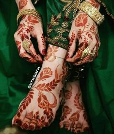 a woman's hands covered in henna and jewelry