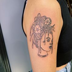 a woman's arm with a tattoo on it that has an image of two women in headdress