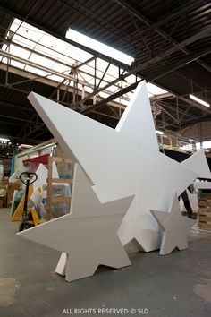 a large white sculpture sitting inside of a warehouse